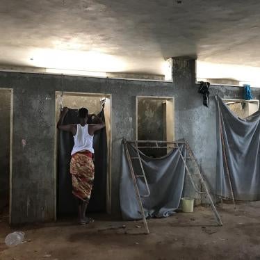 A detainee stands outside a toilet stall in the Ain Zara detention center, Tripoli, July 5, 2018. 