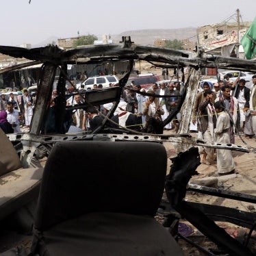 People are seen near a bus destroyed by an airstrike that killed dozens of children, in a photograph taken on August 12, 2018 in Saada, Yemen.