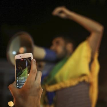 A citizen documenting a street protest with a smartphone in Morocco.