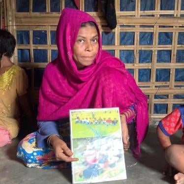 Rahama Khatun holds up photos of her husband who was massacred in Myanmar’s Inn Din village on September 2, 2017, in Cox’s Bazar refugee camp, Bangladesh, August 14, 2019.