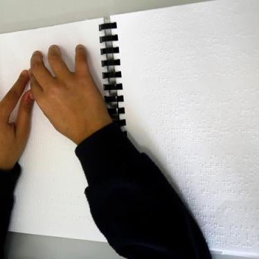 A blind girl reads from a Braille book in a classroom at the Royal Academy for the Blind in Amman.
