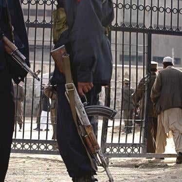 Officers stand guard in front of the Pul-e Charkhi prison's gate in Kabul