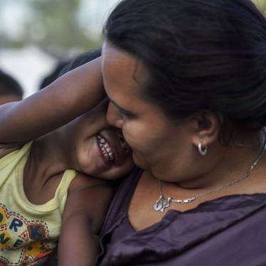 A Honduran mother plays with her son as they wait in line to get a meal in an encampment near the Gateway International Bridge in Matamoros, Mexico, August 30, 2019.