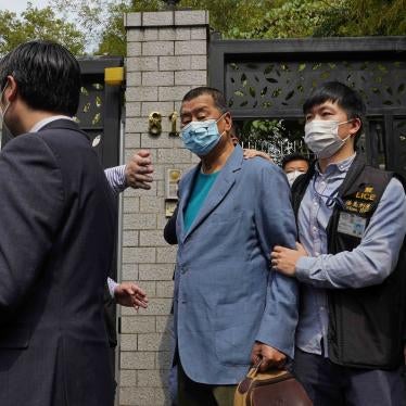 Jimmy Lai, center, Hong Kong media tycoon and founder of local newspaper Apple Daily, is arrested by police officers at his home in Hong Kong, April 18, 2020. 