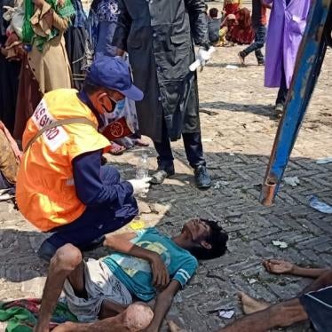 A screenshot of an exhausted Rohingya refugee receiving aid from the Bangladeshi coast guard. ©2020 Bangladeshi Coast Guard/Facebook