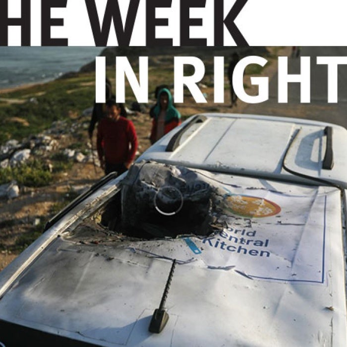 Onlookers approach a destroyed World Central Kitchen vehicle. 